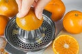 Preparing of mandarin juice, hands squeeze juice on a manual juicer