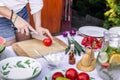 Woman is chopping red tomato on cutting board for vegetable salad Royalty Free Stock Photo