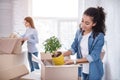 Cheerful young girls unpacking plant and blanket Royalty Free Stock Photo