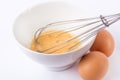 Preparing omelet with whisk and eggs on white desk in kitchen Royalty Free Stock Photo