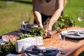 Preparing for an open-air party. Girls decorators decoration with fresh flowers on served tables. Decoration Details Royalty Free Stock Photo