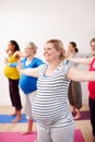 Preparing our bodies for the challenges of motherhood. A multi-ethnic group of pregnant women doing exercises with their
