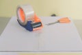 Preparing parcel for shipping with scissors and scotch tape cutter. Royalty Free Stock Photo