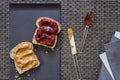 Preparing peanut butter and strawberry jam sandwich