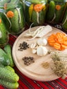 Preparing pickled cucumbers assorted with carrots, garlic, pepper, mustard seeds, celery, dill