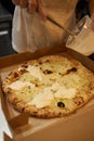 Preparing Pizza Margherita on a marble countertops.Pizzaiolo puts pizza dough on the peel. Royalty Free Stock Photo