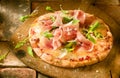 Preparing a proscuitto and rocket pizza