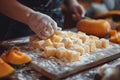 Preparing pumpkin gnocchi, rolling on wooden board.