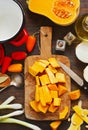 Preparing pumpkin, onions and sweet peppers for cooking around wooden cutting board Royalty Free Stock Photo