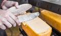 Preparing sandwich at street food market with salmon and raclette melted cheese