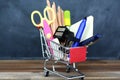 Preparing for school - shopping cart with school supplies over chalkboard Royalty Free Stock Photo