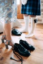 Preparing for a scottish wedding. Man in a kilt and sporran stands next to woman in a skirt and high-heeled shoes. There