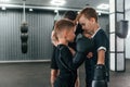 Preparing for the sparring. Young tattooed coach teaching the kids boxing techniques