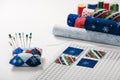 Preparing of square pieces of fabrics for sewing quilt on craft mat, pincushion, fabric rolls, spools of thread Royalty Free Stock Photo