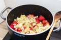 Preparing strawberries and elderflowers jam in black pot Royalty Free Stock Photo