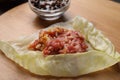 Preparing stuffed cabbage roll on board, closeup