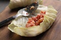 Preparing stuffed cabbage roll on wooden board, closeup