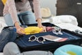 Preparing suitcase for summer vacation trip. Young woman checking accessories and stuff in luggage on the bed at home. Royalty Free Stock Photo