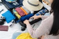 Preparing suitcase for summer vacation trip. Young woman checking accessories and stuff in luggage on the bed at home. Royalty Free Stock Photo