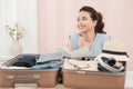 Preparing suitcase for summer vacation trip. Young woman checking accessories and stuff in luggage at home before travel Royalty Free Stock Photo