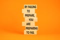 Preparing symbol. Concept words By failing to prepare you are preparing to fail on wooden blocks on a beautiful orange table