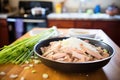 preparing tamales: bowl of masa, filling, corn husks