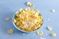 Delicious corn flakes with milk.Milk drops and pieces of corn flakes on the blue background, process of preparing breakfast in the Royalty Free Stock Photo