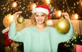 Preparing to Christmas. happy new year. christmas preparation. New year decoration ball. girl in red santa claus hat Royalty Free Stock Photo