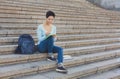 Pretty shorthaired woman sitting on the steps writing in notebook outdoors Royalty Free Stock Photo