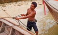 Preparing to take to the ocean. a Thai man preparing his boat before heading out to sea. Royalty Free Stock Photo