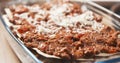 Preparing traditional italian lasagna adding cheese Royalty Free Stock Photo