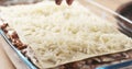 Preparing traditional italian lasagna adding cheese Royalty Free Stock Photo