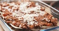 Preparing traditional italian lasagna adding cheese Royalty Free Stock Photo