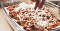 Preparing traditional italian lasagna adding cheese Royalty Free Stock Photo