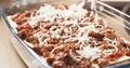 Preparing traditional italian lasagna adding cheese Royalty Free Stock Photo