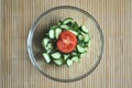 Preparing vegetarian salad, a bowl of vegetables tomato and cucumber, top view