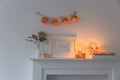 Preparing your home for Halloween. A garland of pumpkins on the wall above fake dresser panel. Frame with the inscription, orange