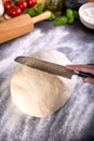 Prepering and cutting pizza dough with knife Royalty Free Stock Photo