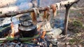 A prepper cooks food on an open fire.