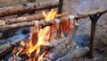 A prepper cooks food on an open fire.