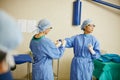 Prepping for surgery as a team. surgeons putting on surgical gloves in preparation for a surgery.