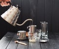 Preraring drip coffee Vietnamese style. Woman hand pouring steaming hot water from goose neck kettle into metal coffee maker phin