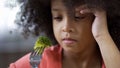 Preschool African girl sadly looking at piece of broccoli on, healthy nutrition