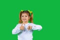 Preschool blonde girl smiles at the camera and shows like and unlike on a green background