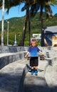 Preschool boy with baseball cap and sketeboard outside in Thailand Royalty Free Stock Photo