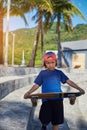 Preschool boy with baseball cap and sketeboard outside in Thailand Royalty Free Stock Photo