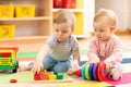 Preschool boy and girl playing on floor with educational toys. Children at home or daycare.