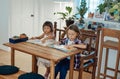 Preschool boy and girl reading a books at table in the kitchen Royalty Free Stock Photo