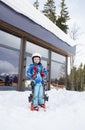 preschool boy in helmet, blue overalls, ski boots stands on the snow, holds skis in hands ready to learn skiing Royalty Free Stock Photo