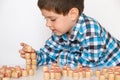 A preschool boy plays lotto, folds barrels with numbers on the table. The child learns to count